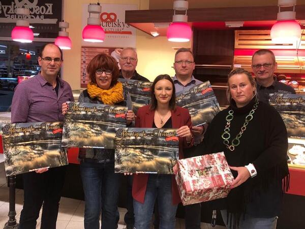 Übergabe von Adventskalendern in einer Bäckerei